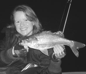 Jo Packman bring another 40cm-plus bass into the kayak for a quick pic before release. A Squidgy Wriggler in Red Rum did the trick.